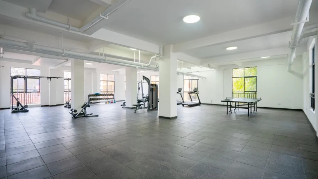 Spacious indoor fitness center with gym equipment and table tennis at Orchid Residency Westlands