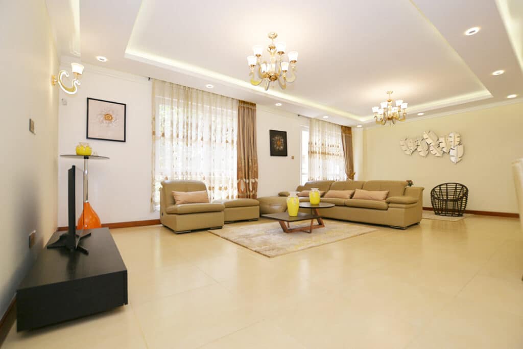 Spacious open-plan living room and lounge area with modern lighting, neutral furnishings, and large windows at Minah Heights Westlands in Westlands, Nairobi.
