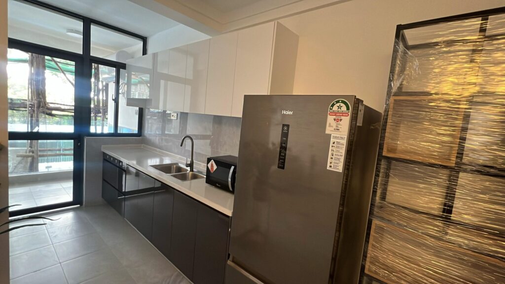 Modern fitted kitchen with two-tone grey and white cabinetry, white countertops, double sink, and stainless steel refrigerator at Serenity Residence in Kilimani, Nairobi.