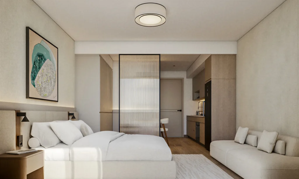 Studio suite interior with double bed, fluted glass partition, and sitting area at Aera Westlands