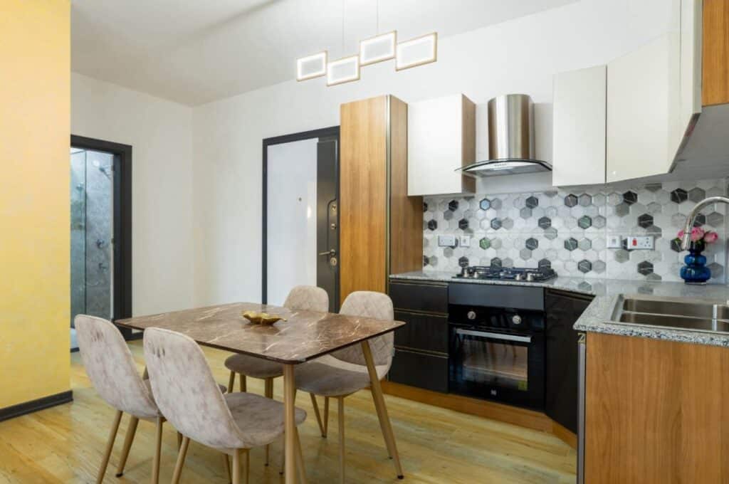 Fitted kitchen with gas hob, extractor hood, built-in oven, and hexagon backsplash tiles at Ambra Heights Kileleshwa