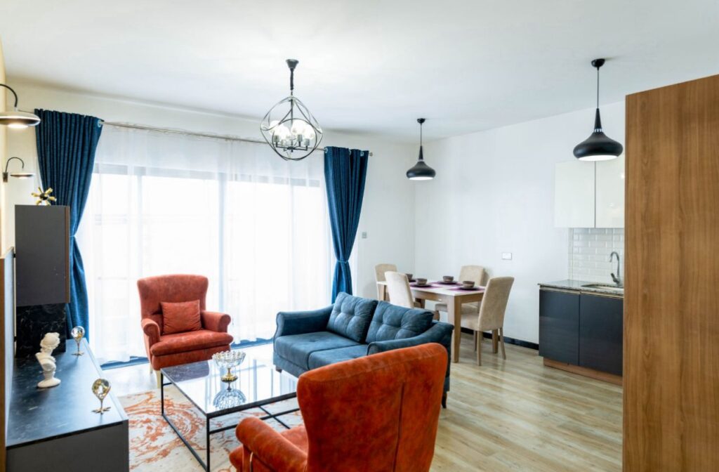 Modern sitting room with teal blue curtains and balcony sliding doors at Ambra Heights Kileleshwa