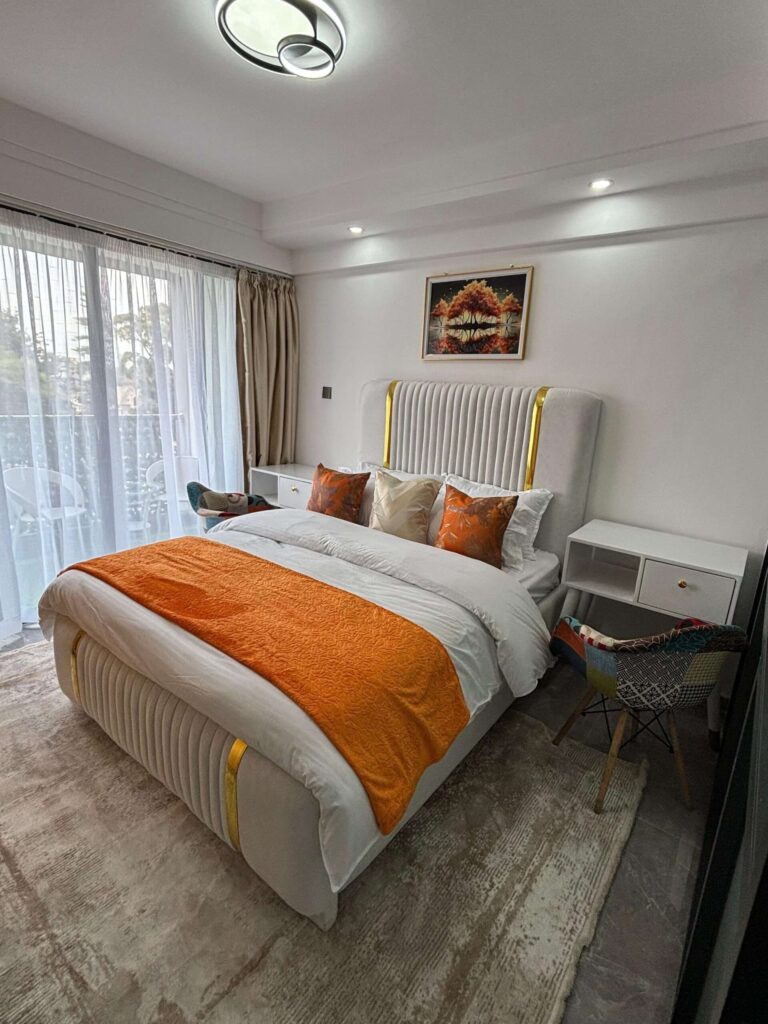 Furnished bedroom with upholstered headboard and balcony access at Gatundu Heights Kileleshwa