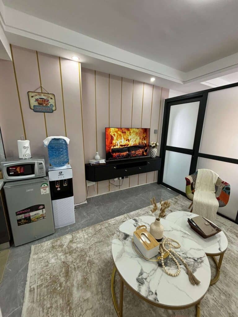 Compact studio apartment living space with wall-mounted TV panel and water dispenser at Gatundu Heights Kileleshwa