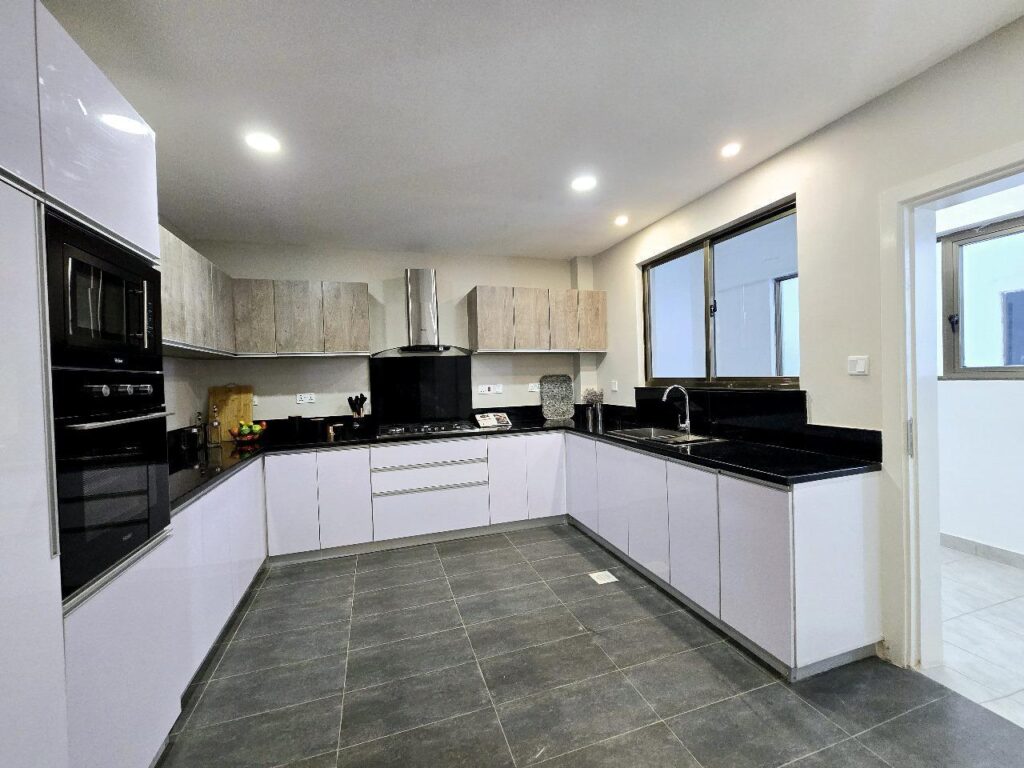 Fitted modern kitchen with dark granite countertops and integrated appliances at Golden Century Apartments