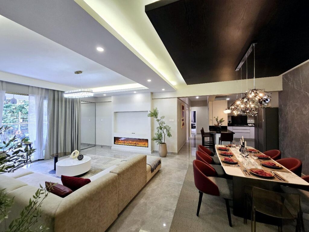 Spacious open-plan living and dining room with electric fireplace at Golden Century Apartments Kileleshwa