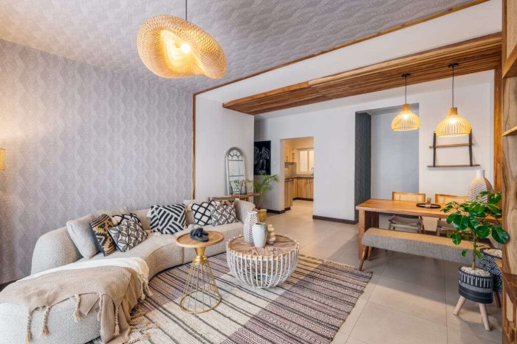 Stylish open-plan living room with curved sofa, bohemian woven light fixture, and adjacent dining area at Sunpark Residences in Syokimau, Nairobi.