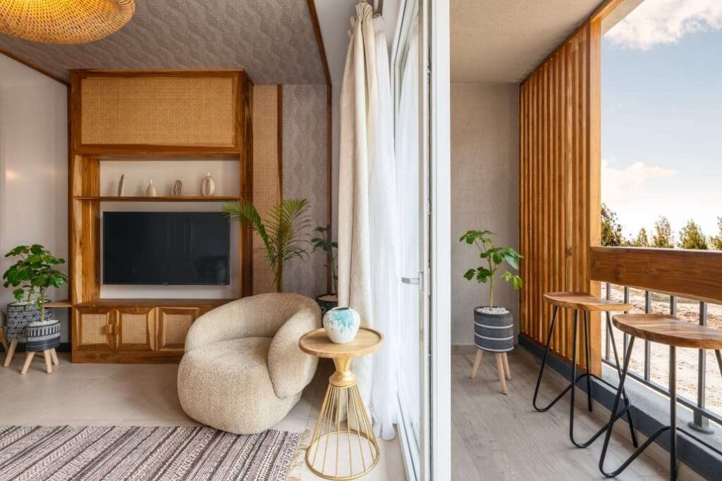 Private apartment balcony featuring a wooden slatted privacy divider and high wooden bar stools at Sunpark Residences in Syokimau, Nairobi.
