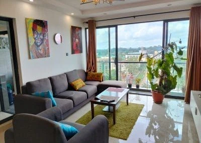 Spacious living room lounge with floor-to-ceiling windows and city view at Urban Oasis Lavington